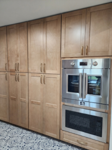 Custom light wood kitchen cabinets with integrated double ovens and microwave by Slater Cabinets and More in Springfield, MO.