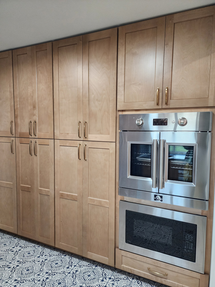 Custom light wood kitchen cabinets with integrated double ovens and microwave by Slater Cabinets and More in Springfield, MO.