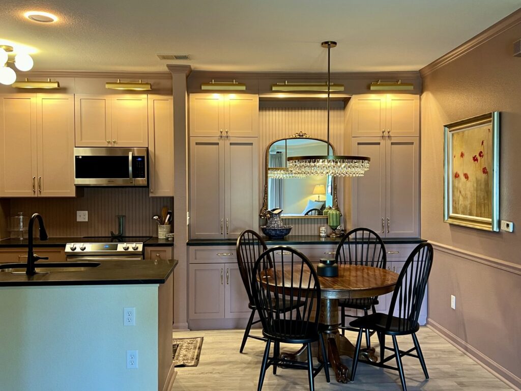 A custom kitchen and dining area featuring built-in cabinetry and elegant lighting by Benjamin Design - Build in Fishers, IN.