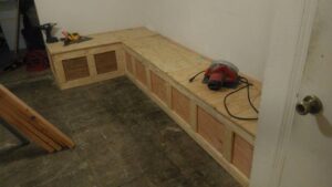A custom L-shaped wooden bench or storage unit being built, demonstrating carpentry services by MG'S Services LLC in Albuquerque, NM.