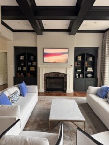 A custom-designed living room with a fireplace, dark built-in shelves, and modern decor by Inova Builds in Bloomington, MN.