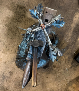 A custom metal cross with decorative leaves being fabricated at Gowan Iron in Montgomery, AL.