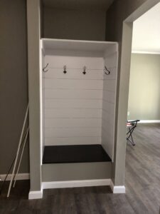 A newly installed custom mudroom bench with hooks, a service provided by Gwen Co in St. Louis, MO.