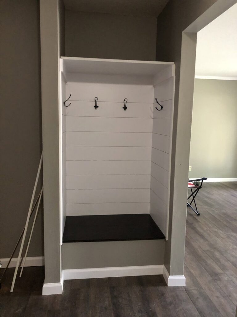 A newly installed custom mudroom bench with hooks, a service provided by Gwen Co in St. Louis, MO.