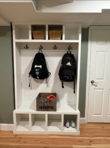 A custom-built mudroom storage unit with hooks and cubbies by Garrett Group Construction in Philadelphia, PA.