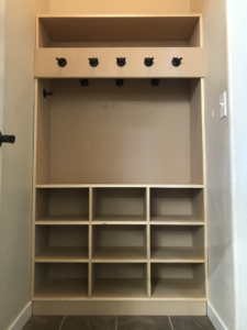 A newly installed custom mudroom organizer with shelves and coat hooks by Corebuilt Contracting LLC in Fort Collins, CO.