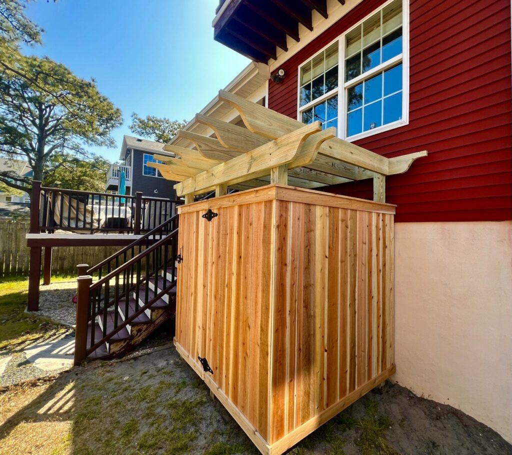 Custom-built outdoor shower enclosure with a wooden pergola top by BOS HOME Exterior Services in Virginia Beach, VA