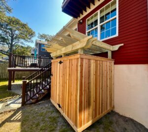 Custom-built outdoor shower enclosure with a wooden pergola top by BOS HOME Exterior Services in Virginia Beach, VA