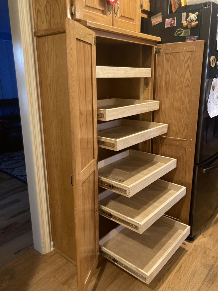 Custom wooden pantry cabinet with pull-out shelves installed by Anderson and Son Services in Olathe, KS