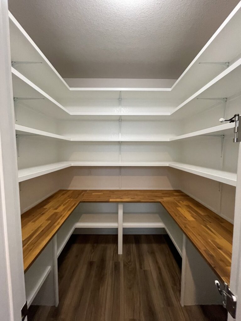 A custom-built pantry with white shelving and wooden countertops installed by Colorado ProBuilt in Aurora, CO