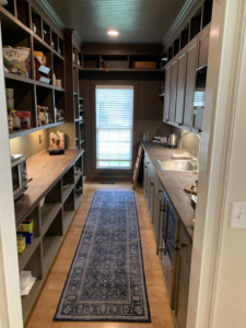 A beautifully organized custom pantry with new shelving and countertops by Heritage Design & Remodel in Raleigh, NC.