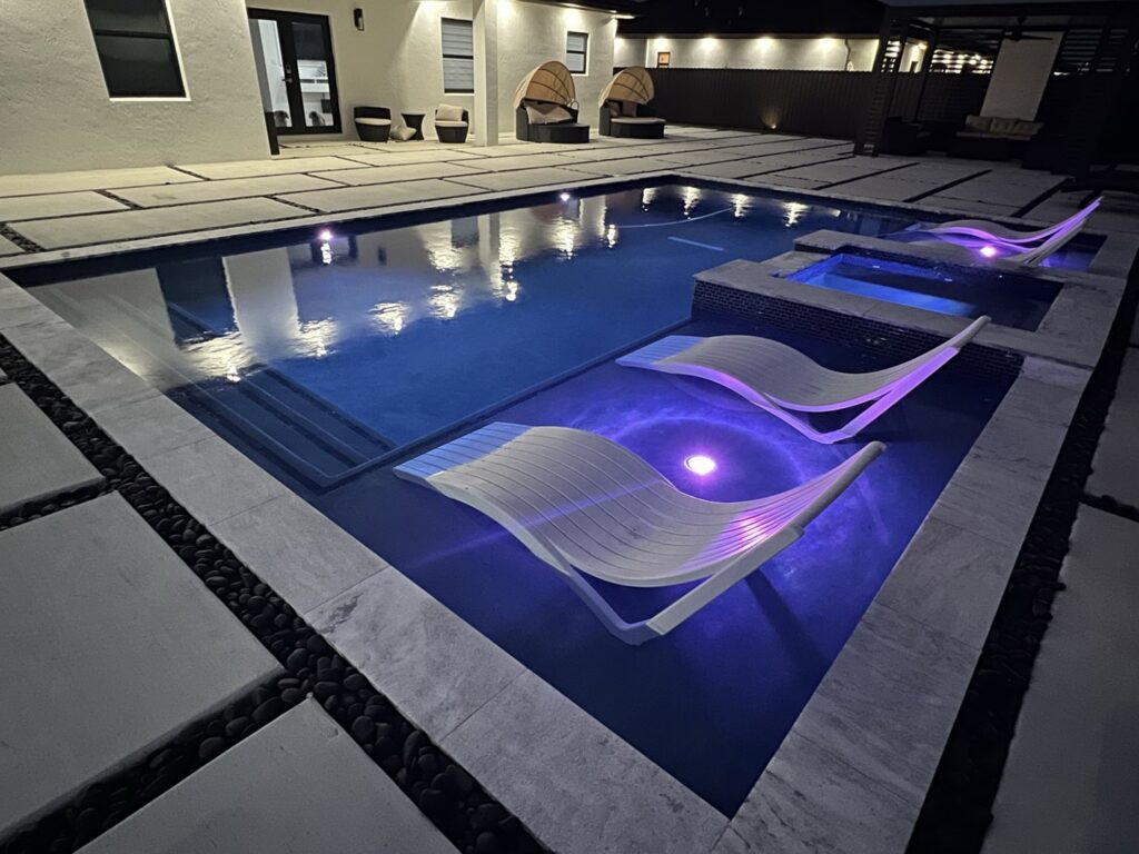 A custom-built pool and spa with elegant lighting, completed by BAFCO POOLS in Hialeah, FL, showcasing a luxurious outdoor space.