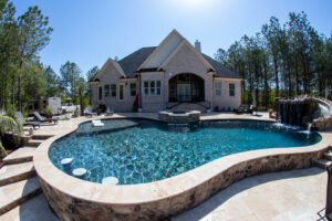 A custom-shaped pool featuring a waterfall and slide, expertly built by Extreme Pools Renovation in Raleigh, NC.