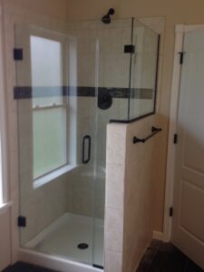 A custom shower featuring light tiles and a functional half-wall, part of a bathroom renovation by Lehigh Shower Glass in Bethlehem, PA