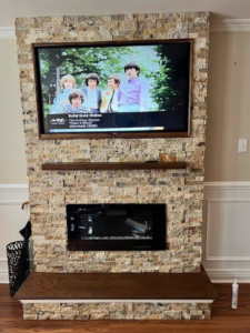 A custom stone fireplace and TV wall installation completed by DunnWright Contractor in Pensacola, FL.