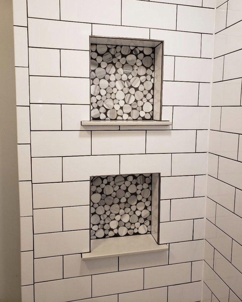 Custom tiled shower wall with two recessed niches featuring decorative pebble-look accent tiles by Ace Tile & Finishing LLC in Philadelphia, PA.