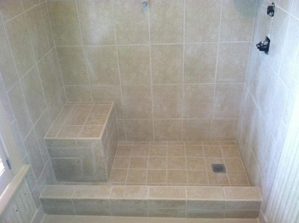 A custom tiled shower featuring a built-in bench and floor drain, completed by Mason Home Improvement Inc. in Newport News, VA.