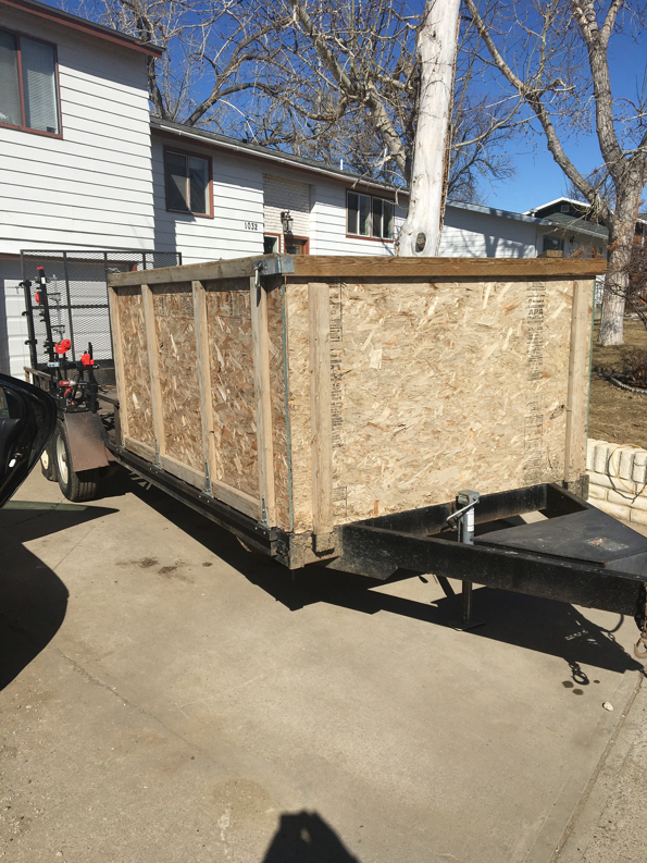 A custom-built trailer with a wooden box, used for hauling tree debris by The Cavalry LLC in Havre, MT.