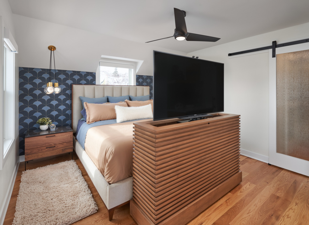 A custom TV lift cabinet and ceiling fan installed in a modern bedroom by EdgeWork Design Build in Minneapolis, MN.