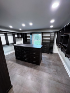 A large custom walk-in closet with dark cabinetry and a central island installed by Shipe Builders in Salisbury, MD.
