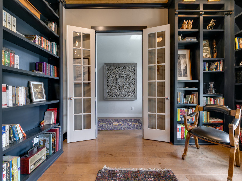 A custom walk-in closet with white cabinetry, ample storage, and a rolling ladder by DFW Improved in Plano, TX.