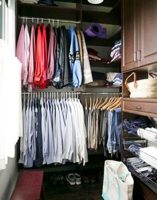 A custom walk-in closet organization system with shelves and hanging rods, installed by Hawkins Enterprise Inc. in Norfolk, VA.