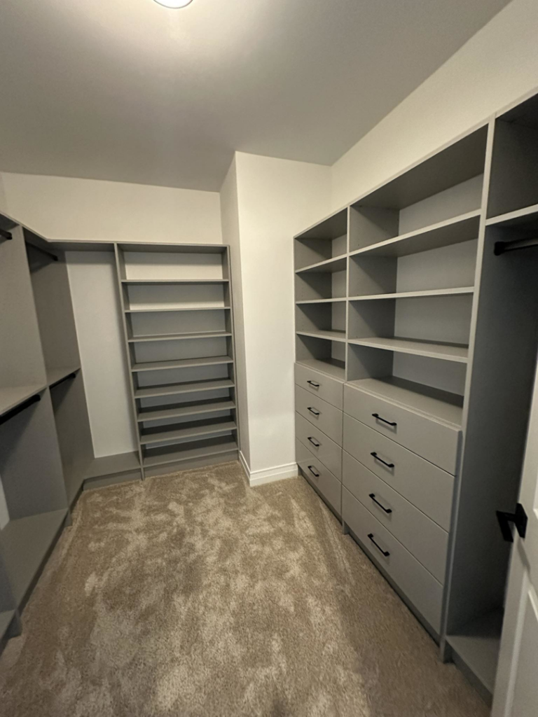 A newly installed custom walk-in closet with shelving and drawers by Construction Components in Puyallup, WA.
