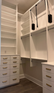 A custom-built walk-in closet with shelving and drawers by Ourso Renovations in Baton Rouge, LA