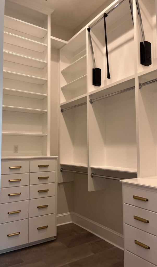 A custom-built walk-in closet with shelving and drawers by Ourso Renovations in Baton Rouge, LA
