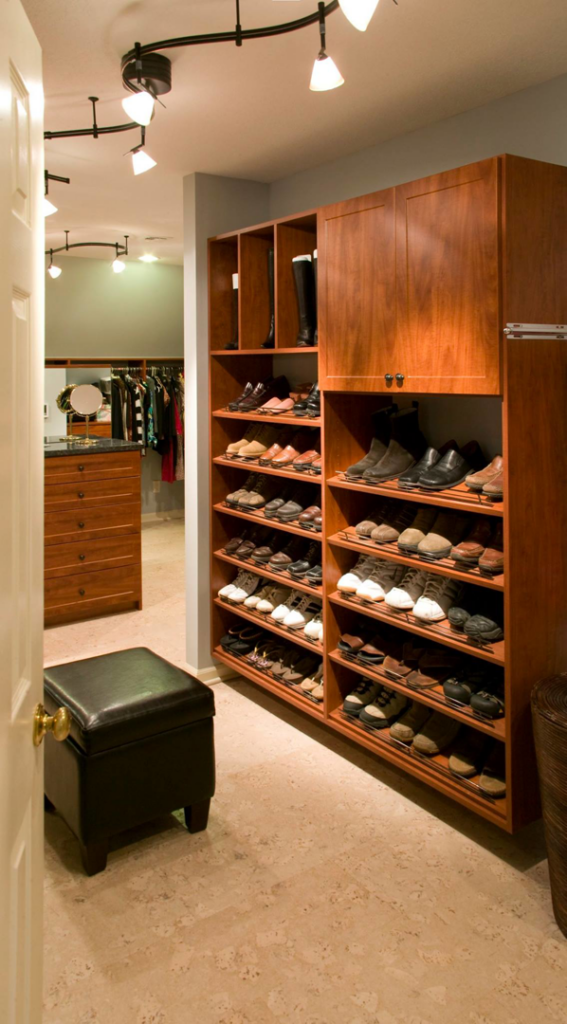 A custom walk-in closet with wooden shelving and track lighting installed by RARE Construction, Inc. in Kansas City, MO.