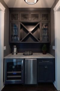 A custom built-in wet bar with dark cabinetry, a wine fridge, and a mini-fridge installed by FEARS Construction in Nashville, TN.
