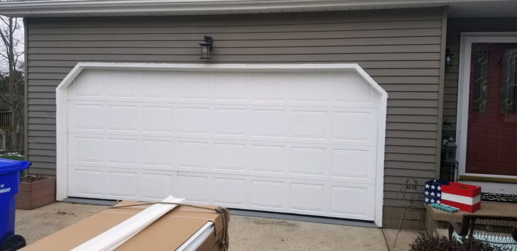 A custom white garage door with an angled top frame installed by Lucas Overhead Doors, a general contractor in Erie, PA