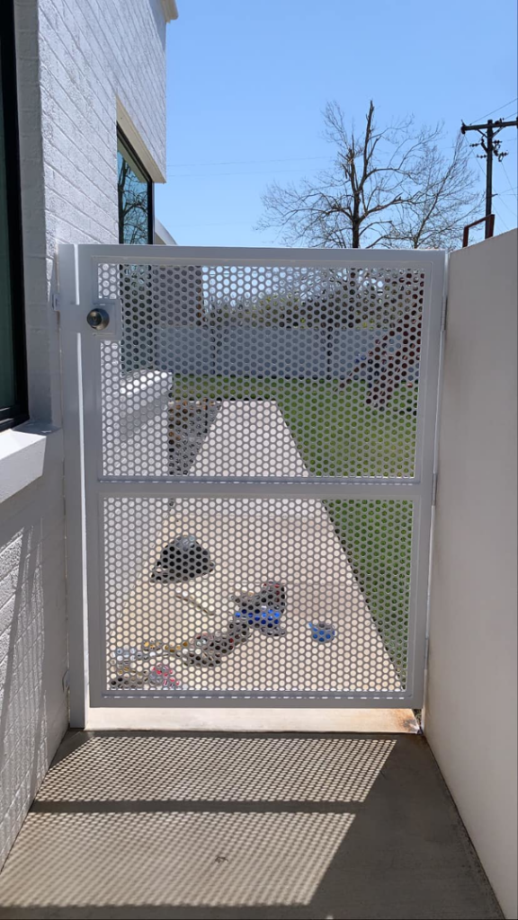 A custom white perforated metal gate installed as part of a handyman service by Tallgrass fabrication in Edmond, OK.
