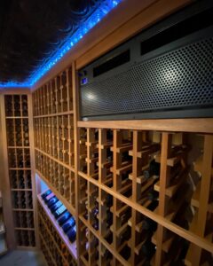A custom-built wine cellar featuring wooden racks and a climate control unit, installed by Bob Build's WNY in Buffalo, NY.