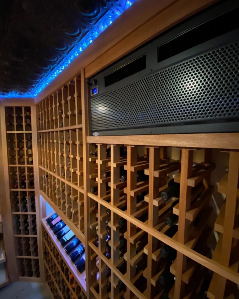 A custom-built wine cellar featuring wooden racks and a climate control unit, installed by Bob Build's WNY in Buffalo, NY.