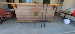 A custom-built wooden bar with decorative accents and wheels, a carpentry project by Montano's Handyman in Fresno, CA