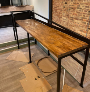 A custom wooden bar with a metal frame being installed by North Shore Construction & Renovation in Philadelphia, PA.