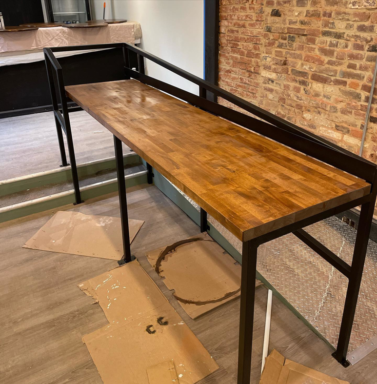 A custom wooden bar with a metal frame being installed by North Shore Construction & Renovation in Philadelphia, PA.