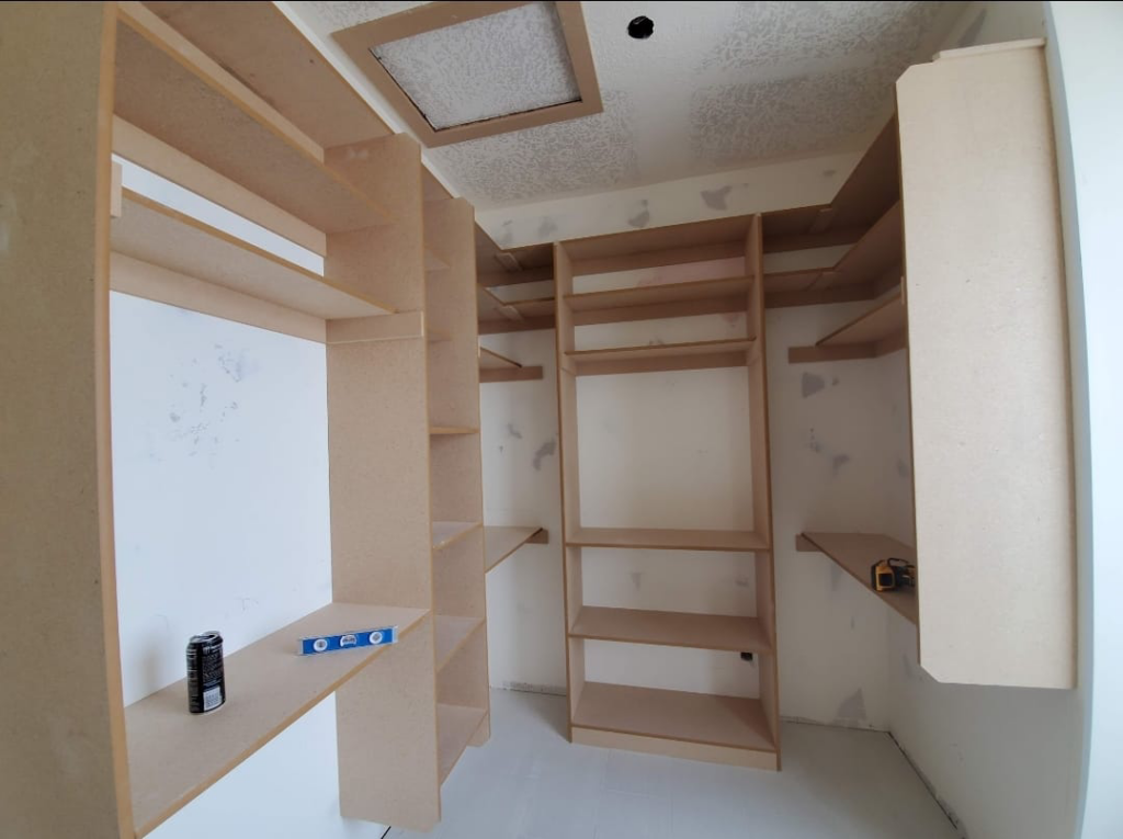 Custom wooden closet shelving being installed by Blue Ridge Customs LLC in a Raleigh, NC home.