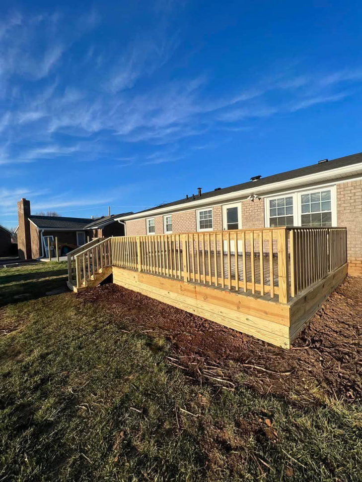 A custom-built wooden deck with sturdy railings and stairs, completed by Matt Hingle Construction for a home in Bowling Green, KY.