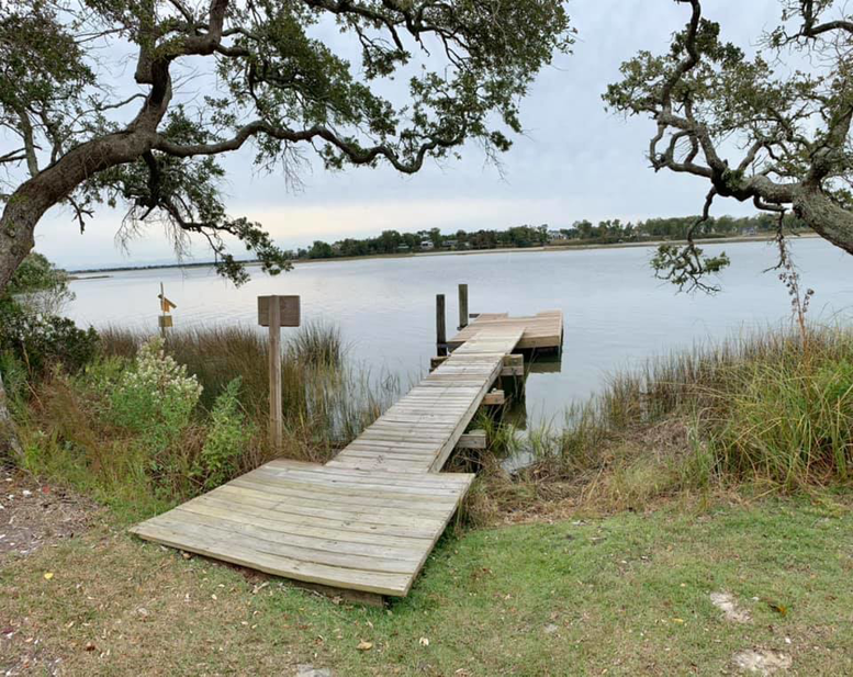 A custom wooden dock built by Southeast Custom Homes extending into the water in Wilmington, NC.