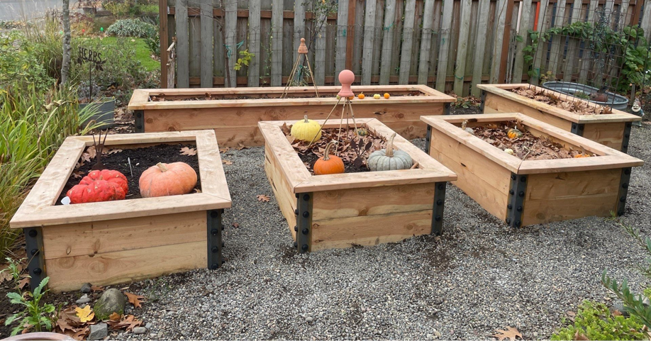 Several custom-built wooden raised garden beds with decorative metal accents by PNW Home Improvements, LLC in Portland, OR