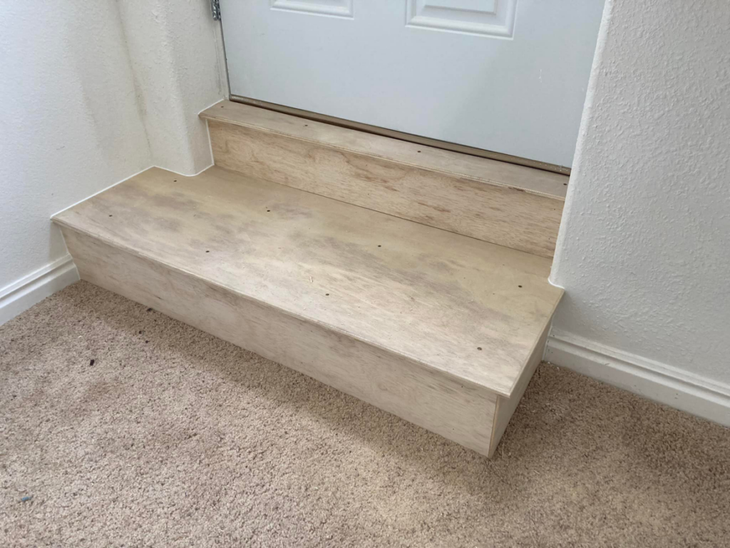 Newly constructed custom wooden steps leading to a doorway, a handyman carpentry service by JMY Construction in Meridian, ID.