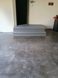 Newly built and installed gray wooden steps leading to a door by The Cowboy Carpenter Handyman Service LLC in Bismarck, ND.