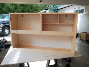 An unfinished custom-built wooden wall cabinet with shelves, crafted by Boise Handyman & Remodel in Boise, ID.