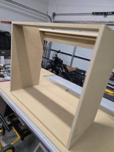 A custom woodworking project, possibly a cabinet or shelf, being built in a workshop by Creekside Handyman NWA in Centerton, AR.