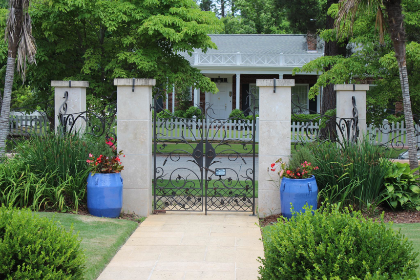 A beautifully installed custom wrought iron gate with decorative pillars by Gowan Iron in Montgomery, AL.