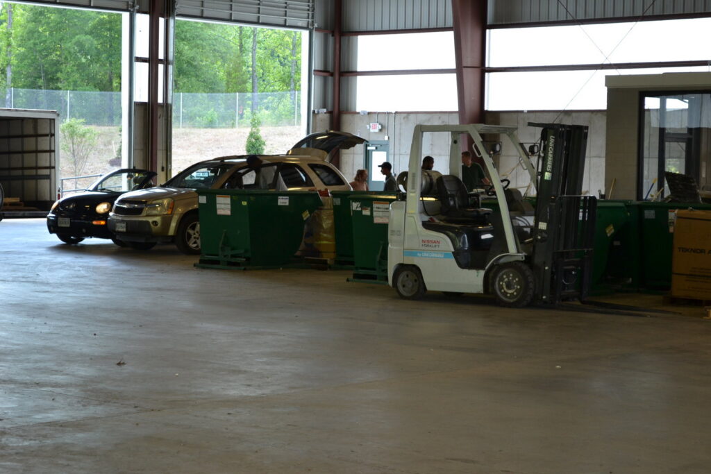 Customers dropping off junk and scrap materials at the Bee Green Recycling facility with a forklift in Richmond, VA
