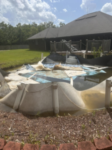 A damaged and collapsed above-ground pool awaiting removal by Weekly Waste Solutions in Jackson, MS.