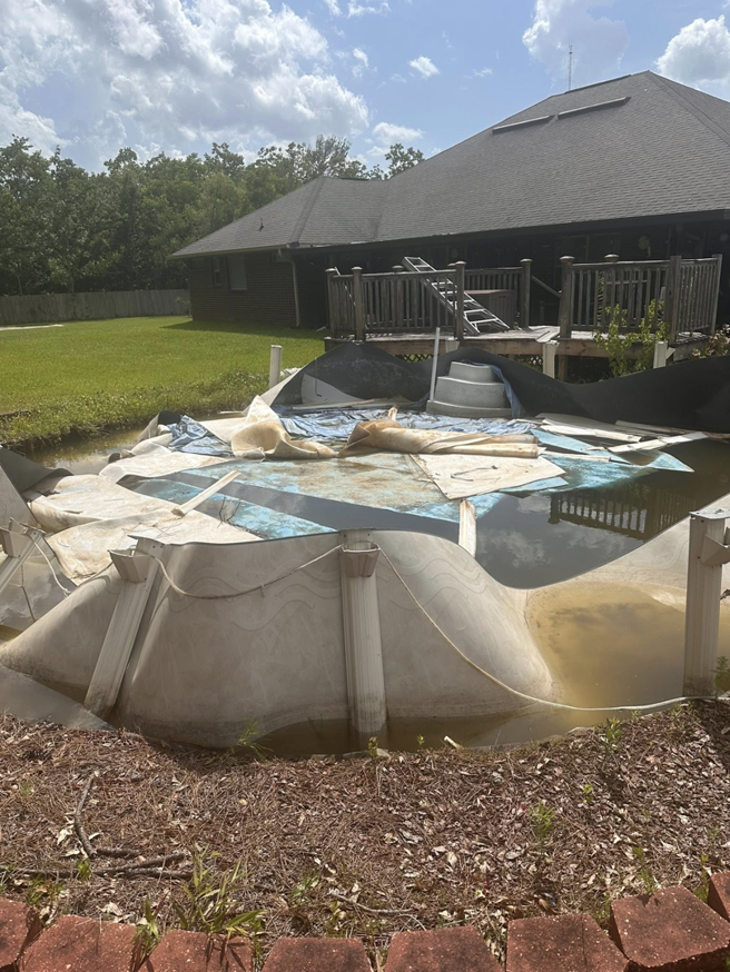 A damaged and collapsed above-ground pool awaiting removal by Weekly Waste Solutions in Jackson, MS.